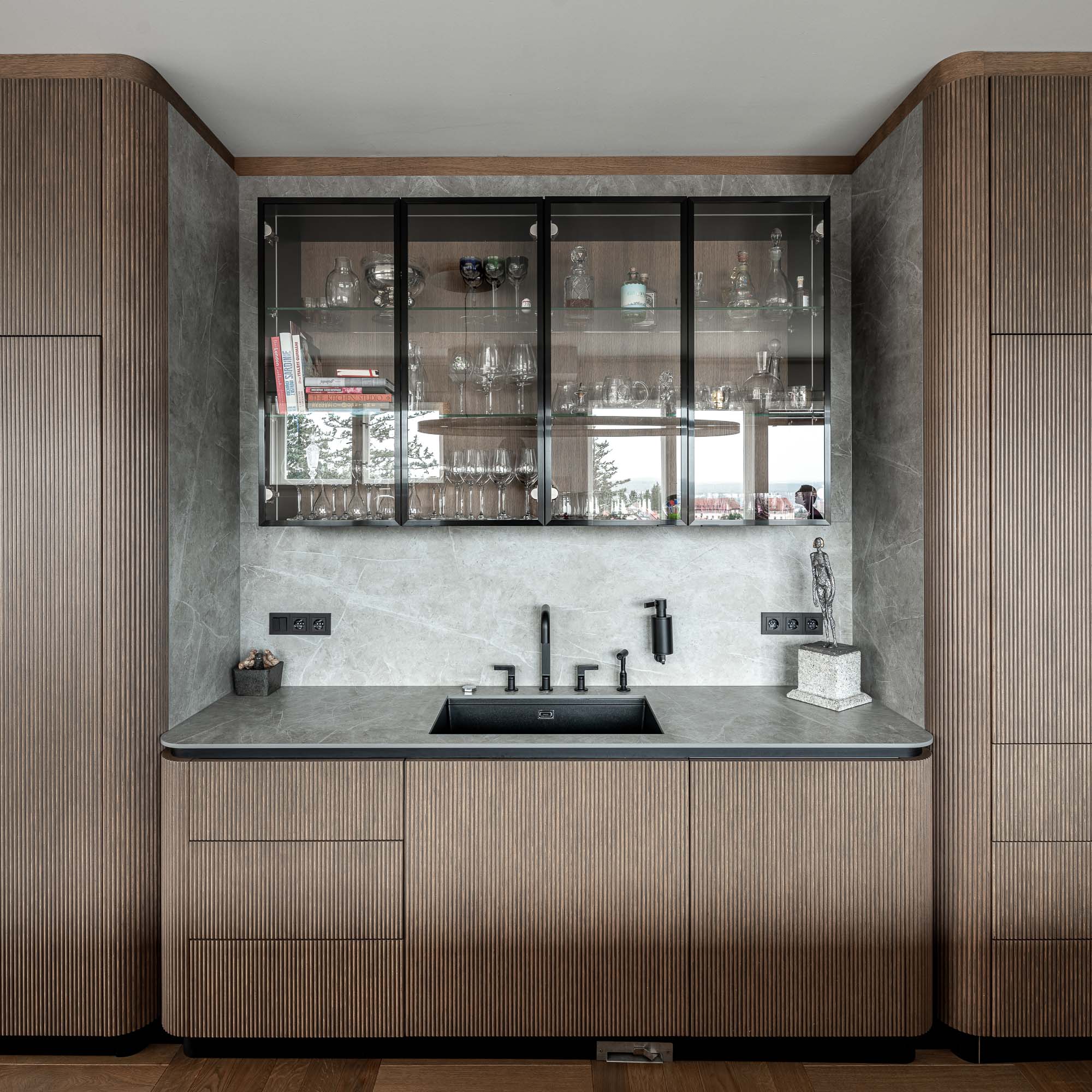 Ribbed veneer kitchen units with a view of the terrace through glazed doors in the Brno apartment